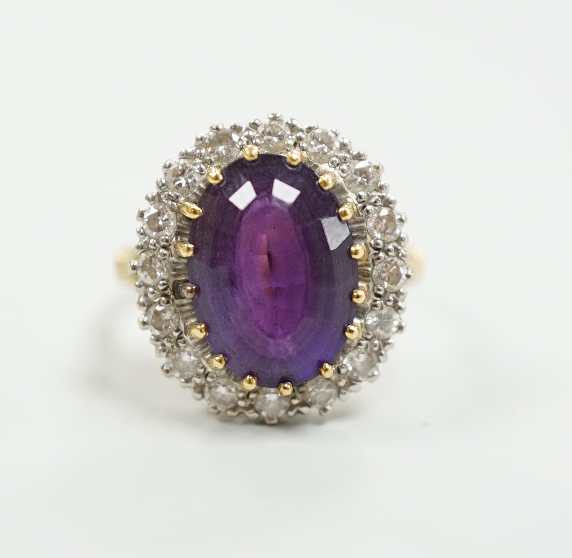 A yellow metal, amethyst and diamond set oval cluster dress ring, size K, gross weight 7.5 grams.